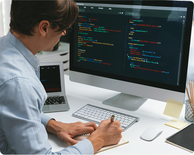 Developer working at a desk with code on screen